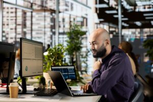 An IT services employee examines school security data and cloud services.