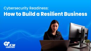 Woman working on a laptop and desktop, highlighting cyber threats, data breach prevention, and risk management for resilient businesses.
